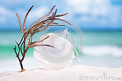 Christmas glass ball on white sand beach with seascape backgrou Stock Photo