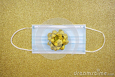 Christmas golden deco baubles on golden background with surgical protective mask. New year on quarantine. Flat lay design. Copy Stock Photo