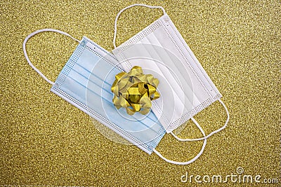 Christmas golden deco baubles on golden background with two surgical protective masks: for adult and for child. New year on Stock Photo