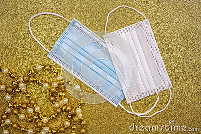 Christmas golden decorative ornaments on golden background with two surgical protective masks: for adult and for child. New year Stock Photo