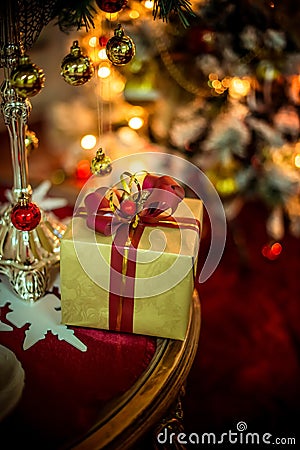 Christmas golden present behind the lights of a Christmas tree Stock Photo