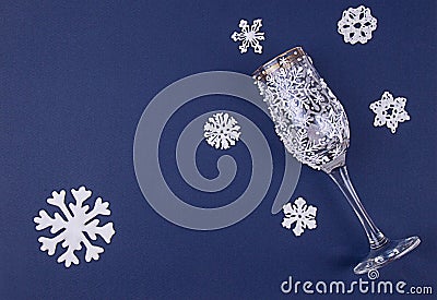 Christmas greeting card with decoration snoflakes made of sugar icing and wine glass decorated with icing on deep blue background Stock Photo