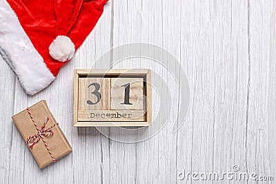 christmas hat, gift and wooden calendar 31 december on a wooden background Stock Photo