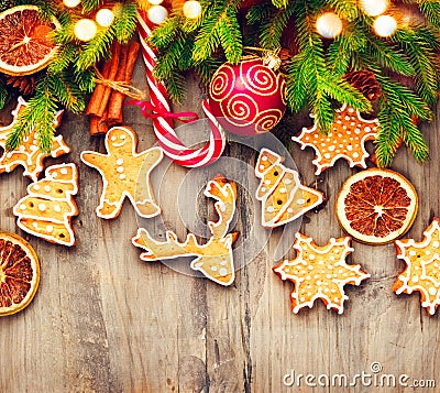 Christmas holiday border with gingerbread cookies, candy cane over wood Stock Photo