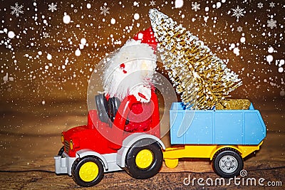 Christmas holiday celebration theme. Santa Claus carries Christmas tree on tractor with trailer. Stock Photo