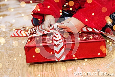 CHRISTMAS, HOLIDAYS AND CHILD CONCEPT, CLOSE-UP LITTLE BOY OPENING BOX GIFT OS SANTA CLAUS Stock Photo