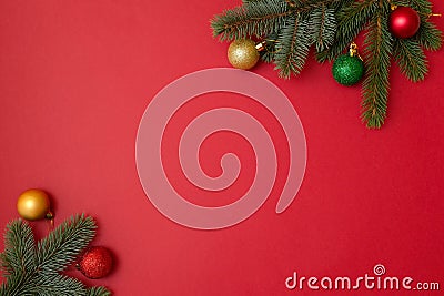 Christmas holidays composition on red background with copy space for your text. Xmas tree fir branches with balls in the corners, Stock Photo