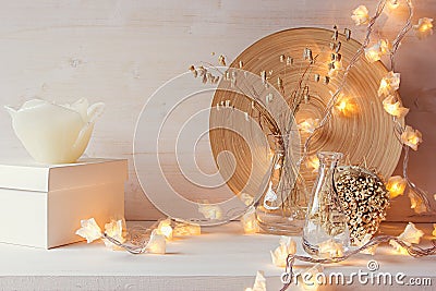 Christmas home decoration with burning lights on white wooden background. Stock Photo