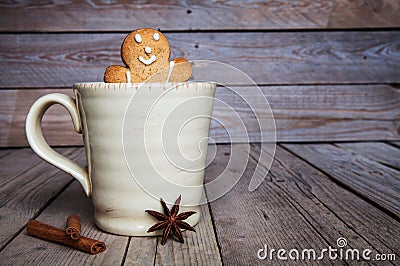 Christmas homemade gingerbread man on wooden background. Large cup of coffee. Cinnamon and star anise Stock Photo