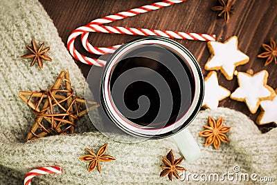 Christmas hot steaming cup of glint wine with spices, anise, cookies in a shape of star, red candies, pepper and gray scarf on Stock Photo