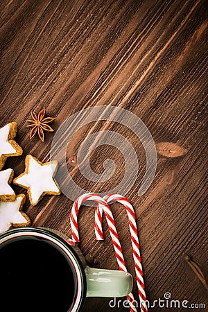 Christmas hot steaming cup of glint wine with spices, anise, cookies in a shape of star, red candies, pepper on wooden background Stock Photo