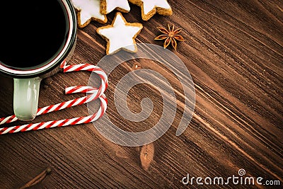 Christmas hot steaming cup of glint wine with spices, anise, cookies in a shape of star, red candies, pepper on wooden background Stock Photo