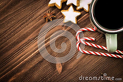 Christmas hot steaming cup of glint wine with spices, anise, cookies in a shape of star, red candies, pepper on wooden background Stock Photo