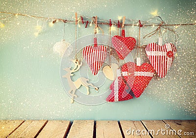 Christmas image of fabric red hearts and tree. wooden reindeer and garland lights, hanging on rope Stock Photo