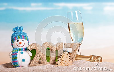 Christmas 2017 inscription, champagne, snowman in the sand Stock Photo