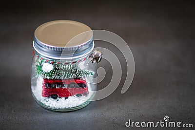 Christmas jar with a tiny red car and christmas tree on the snow inside Stock Photo