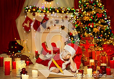 Christmas Kid Write Wish List, Child Santa Hat Writing Letter Stock Photo