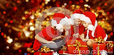 Christmas Kids Opening Present Gift Box, Children in Santa Hat Stock Photo