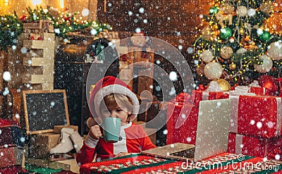 Christmas kids in snow. Boy child with laptop near christmas tree. Buy christmas gifts online. Christmas shopping Stock Photo