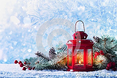 Christmas lantern in snow with fir tree branch. Winter cozy scene Stock Photo