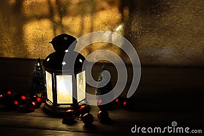 Christmas lantern with snowfall, candles, view from the window on the night street Stock Photo