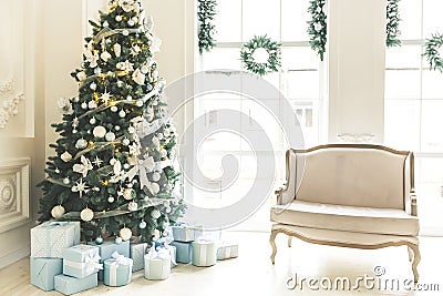 Christmas living room with a fireplace, sofa, Christmas tree, gifts and a large window. Beautiful New Year decorated classic Stock Photo