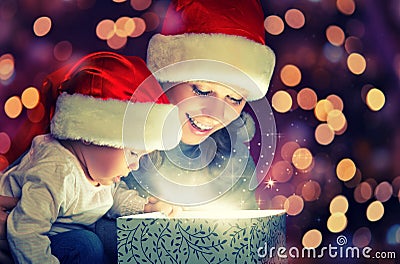 Christmas magic gift box and a happy family mother and baby Stock Photo