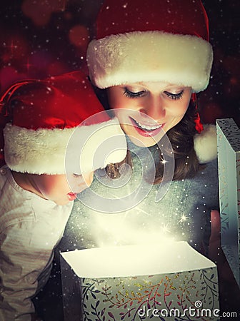 Christmas magic gift box and a happy family mother and baby Stock Photo