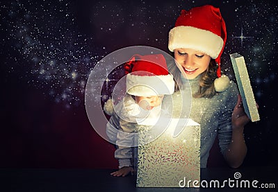 Christmas magic gift box and a happy family mother and baby Stock Photo