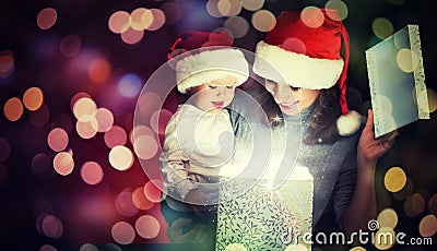 Christmas magic gift box and a happy family mother and baby Stock Photo