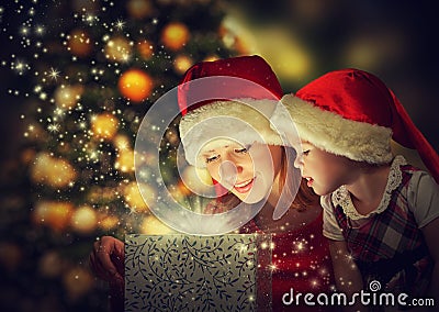 Christmas magic gift box and a happy family mother and daughter baby girl Stock Photo