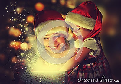 Christmas magic gift box and a happy family mother and daughter baby girl Stock Photo