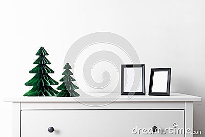 Christmas mock up with black frame and Honeycomb tree paper decor. Square frame on a wooden shelf against a white wall Stock Photo