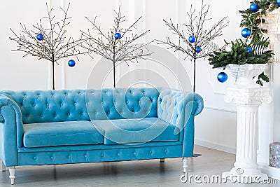 Christmas morning, copy space. Classic apartments with blue buttoned sofa, decorated fir tree. Stock Photo