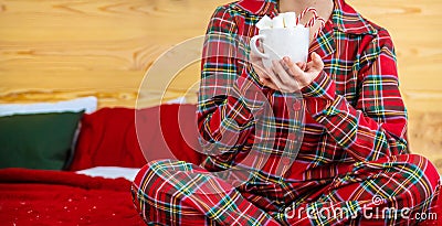 Christmas morning, girl in pajamas with a cup of hot cocoa with marshmallows. Selective focus Stock Photo