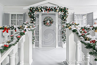 Christmas morning. porch a small house with a decorated door with a Christmas wreath. Winter fairy tale. Stock Photo