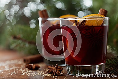 Christmas mulled wine or gluhwein with spices and orange slices on rustic table, traditional drink on winter holiday, magic light Stock Photo