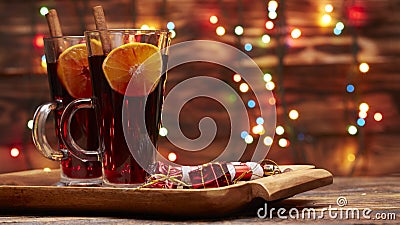 Christmas mulled wine red in a glass with stick of cinnamon and a piece of orange on a background of twinkling lights Stock Photo