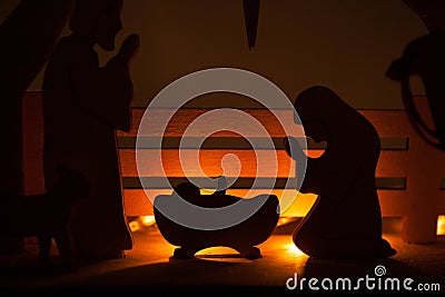 Christmas Nativity Scene of baby Jesus in the manger with Mary and Joseph in silhouette surrounded by the animals Stock Photo