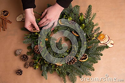 Christmas natural wreath. Florist s hands making natural Christmas wreath, christmas decorations with natural fir branches Stock Photo