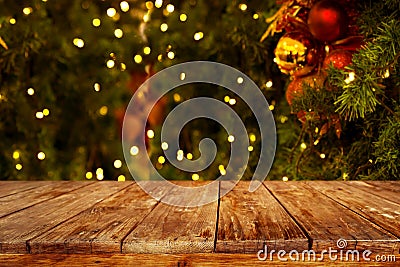 Christmas and New year background with empty dark wooden deck table over christmas tree and blurred light bokeh. Stock Photo