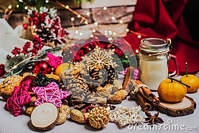 Christmas and new year celebration table decoration background with garland, toys, cookies, cinnamon, pine cones, wallnuts and Stock Photo