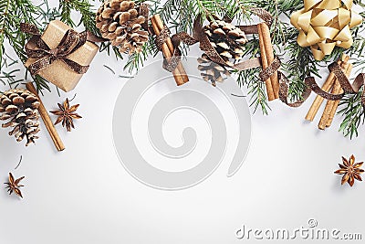 Christmas and New Year composition. Gift box with ribbon, fir branches with cones, star anise, cinnamon on white background Stock Photo