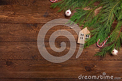 Christmas or New Year flat lay decoration background: cypress branches, wooden house, candy cane, on dark wooden background Stock Photo