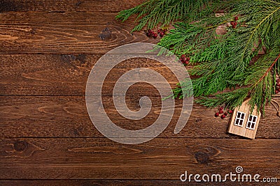 Christmas or New Year flat lay decoration background: cypress branches, wooden house, on dark wooden background Stock Photo