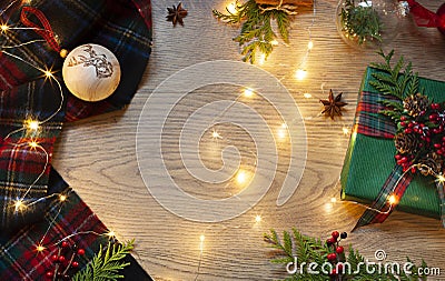 Christmas, New Year frame with Scottish tartan pattern and festive lights on the wooden background. Stock Photo