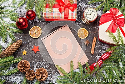 Christmas fir trees in snow with cones, anise stars, cinnamon sticks, vintage clock, decorative stars, christmas balls, and giftbo Stock Photo