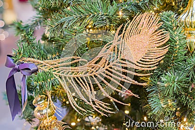 Christmas and New Year holidays background. Christmas tree decorated with gpld feather. Celebration concept Stock Photo