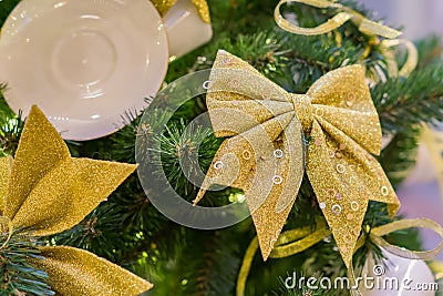 Christmas and New Year holidays background. Christmas tree decorated with white cups ans sauces and golden bows. Trendy concept Stock Photo