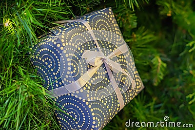 Christmas and New Year holidays background. Christmas tree with garland and giftbox with a bow Stock Photo
